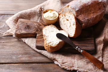 Fresh bread and homemade butter on wooden background