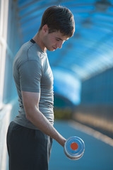 Fototapeta premium Athletic man doing exercises dumbbells