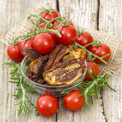 fresh and dried tomatoes on wooden background