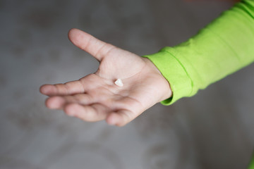A baby tooth on a child's hand