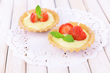 Tasty tartlets with strawberries on table close-up