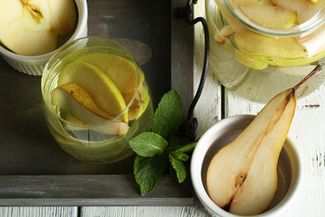 Sangria drink in glass and jar on wooden background
