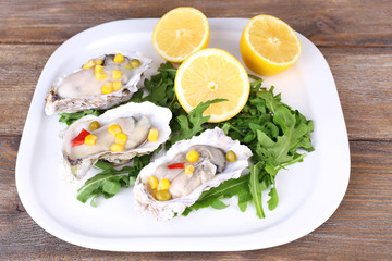 Tasty cooked oysters in shell on wooden table