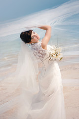 Fototapeta na wymiar Portrait of beautiful bride standing by the beach