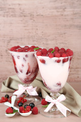 Tasty raspberry dessert with berries on pink wooden background