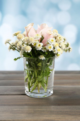 Beautiful flowers on table, on bright background