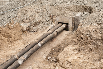Alte Fernwärmerohre verlaufen in einen Betonschacht