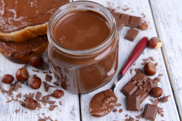 Sweet chocolate cream in jar on table close-up