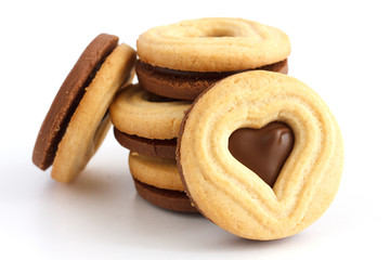 Stack of mixed white and dark biscuits with heart shape cut out.