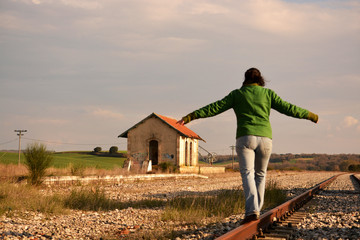 mujer haciendo equilibrio en las vias del tren