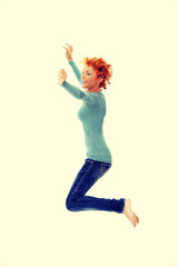 Young happy caucasian woman jumping in the air
