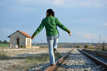 mujer haciendo equilibria en las vias del tren