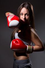 Beautiful girl with the boxing gloves,dark background