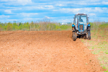 Obraz premium tractor plowed field in spring
