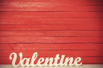 wooden word Valentine on red background.