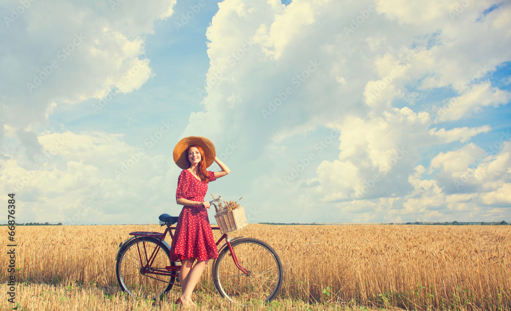 Sticker Redhead peasant girl with bicycle on wheat field.