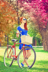 Fototapeta na wymiar Redhead with bicycle in the park.