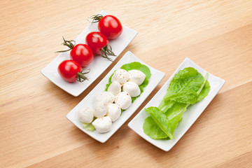 Tomatoes, mozzarella and green salad leaves