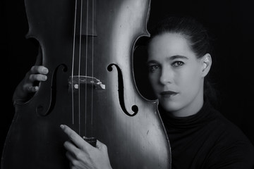Beautiful brunette playing a cello with selective light in black © Alta Oosthuizen