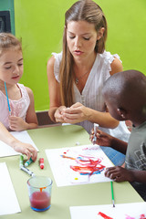 Children painting with tempera color in kindergarten