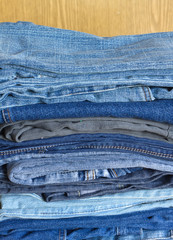 Many jeans on sandy brown background close-up