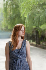 Young ginger haired women posing outside in city park