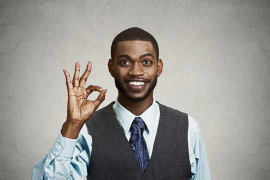Portrait Business man giving ok sign, grey wall background 