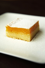 close up lemon cheese cake in white dish
