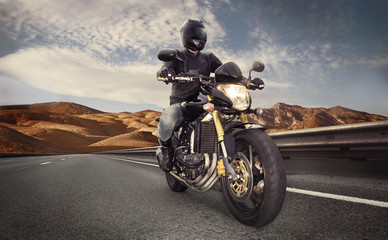 Man seat on the motorcycle on the desert road