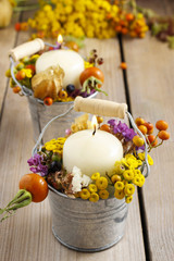 Silver bucket with autumn flowers and other plants.