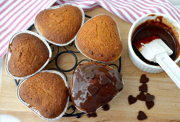 Homemade cakes are being coated with chocolate icing .