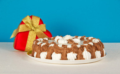 Dish with biscuit, gift heart on white cloth