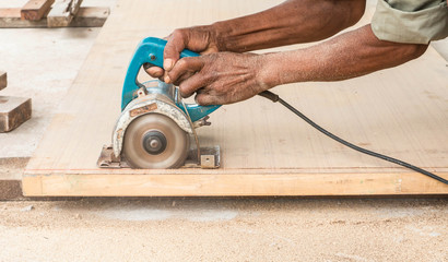 carpenter working with plane on wooden background