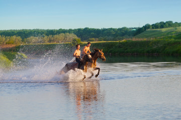 Obraz na płótnie Canvas Two young men gallop on horses on water