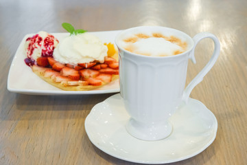 Cappuccino coffee cup and vanilla ice cream with strawberry and