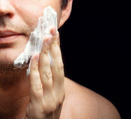 Young man applying a shaving foam