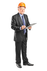 Mature construction supervisor holding a clipboard