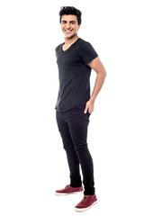 Casual man standing with his hands behind