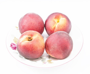 four whole ripe peach on a plate