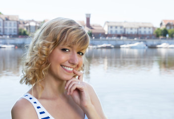 Fototapeta premium Young woman on a river laughing at camera