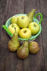 Fresh green apples and pears on a wooden table