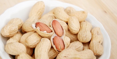 pot with peanuts upward wooden table