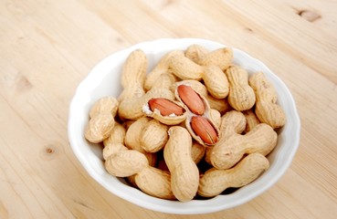 pot with peanuts upward wooden table