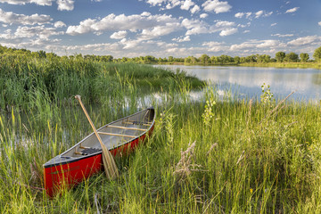 red canoe on lake shore