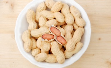 pot with peanuts upward wooden table