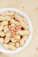 pot with peanuts upward wooden table