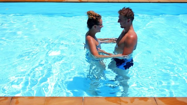 Young Couple Hugging in the Blue Outdoor Pool in Luxury Villa.