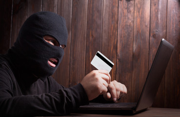 Hacker holding a credit card