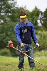 Man working with grass trimmer