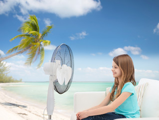 smiling little girl with big fan at home